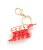 A keychain with text in white and red capital letters that read "Stay positive".