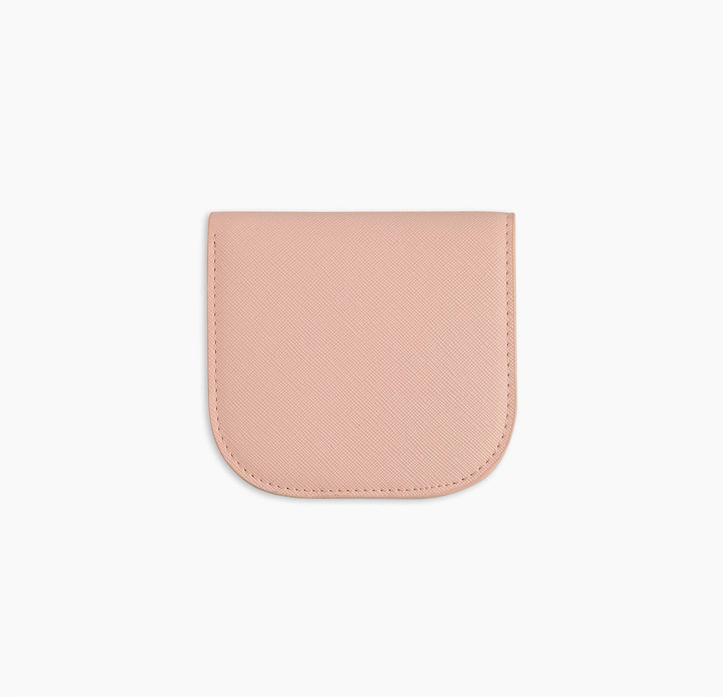 A pink vegan leather wallet before a white background.