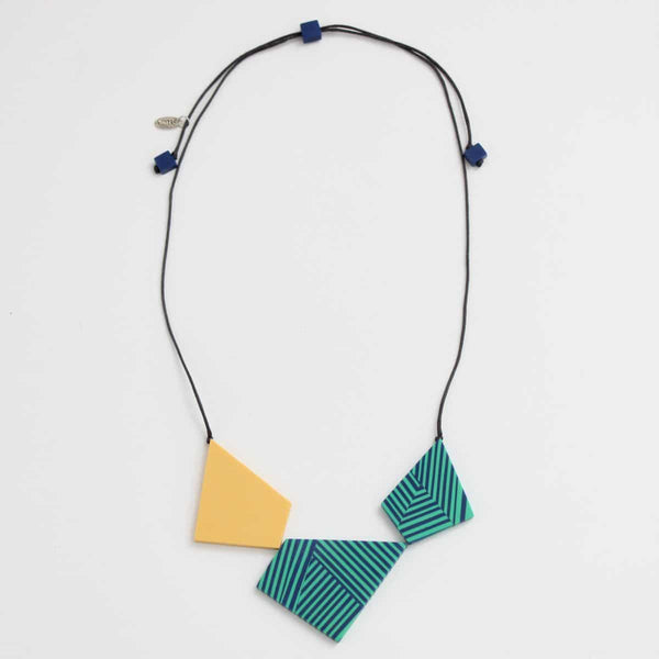 A necklace features teal and blue stripped geometric beads accented with yellow, and hangs on an adjustable black cord. 