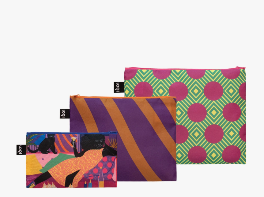 Three recycled zip pocket bags with bold colors and abstract prints. The smallest bag shows a woman laying down on her couch with her cat.