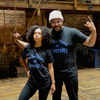 A man and a woman with a dark skin tone are modeling t-shirts with blue text that say: "Black t-shirt with blue text that reads: "Are you Afraid of Diversity?"