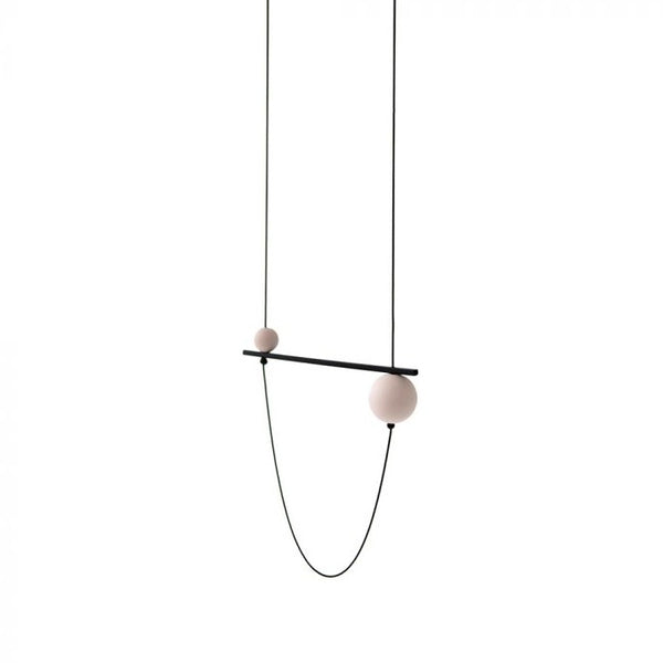 A mixed media designed geometric necklace featuring a black bar and two white orbs.