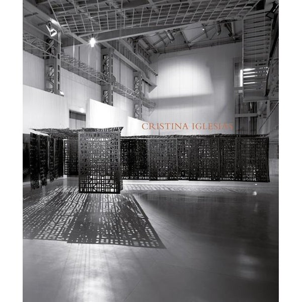 A book cover with a black and white photograph of a large warehouse with an installation and text reading "Cristina Iglesias."